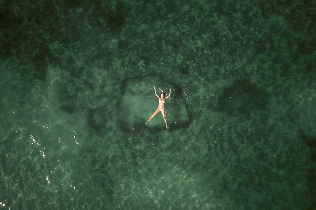 a person floating in the ocean on a surfboard